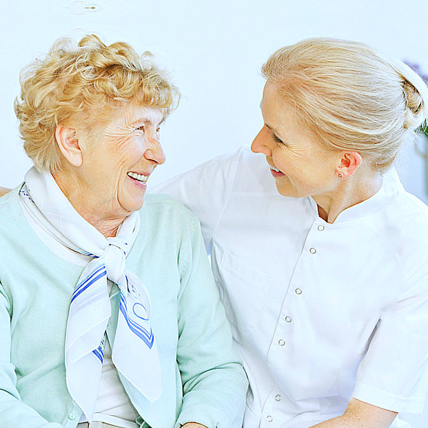 caregiver and senior woman smiling together